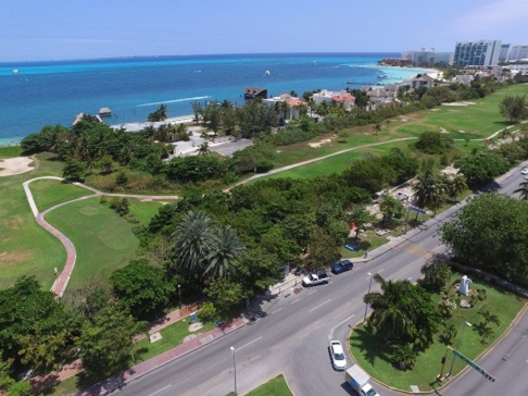 Vista aérea de vialidades del boulevard Kukulcán y Campo de Golf Pok Ta Pok y al fondo la playa ubicada en el km 7+500.
