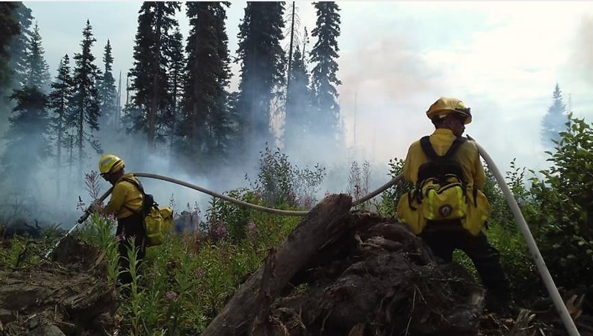 Combatientes mexicanos tienten manguera para atacar incendio en Canadá.