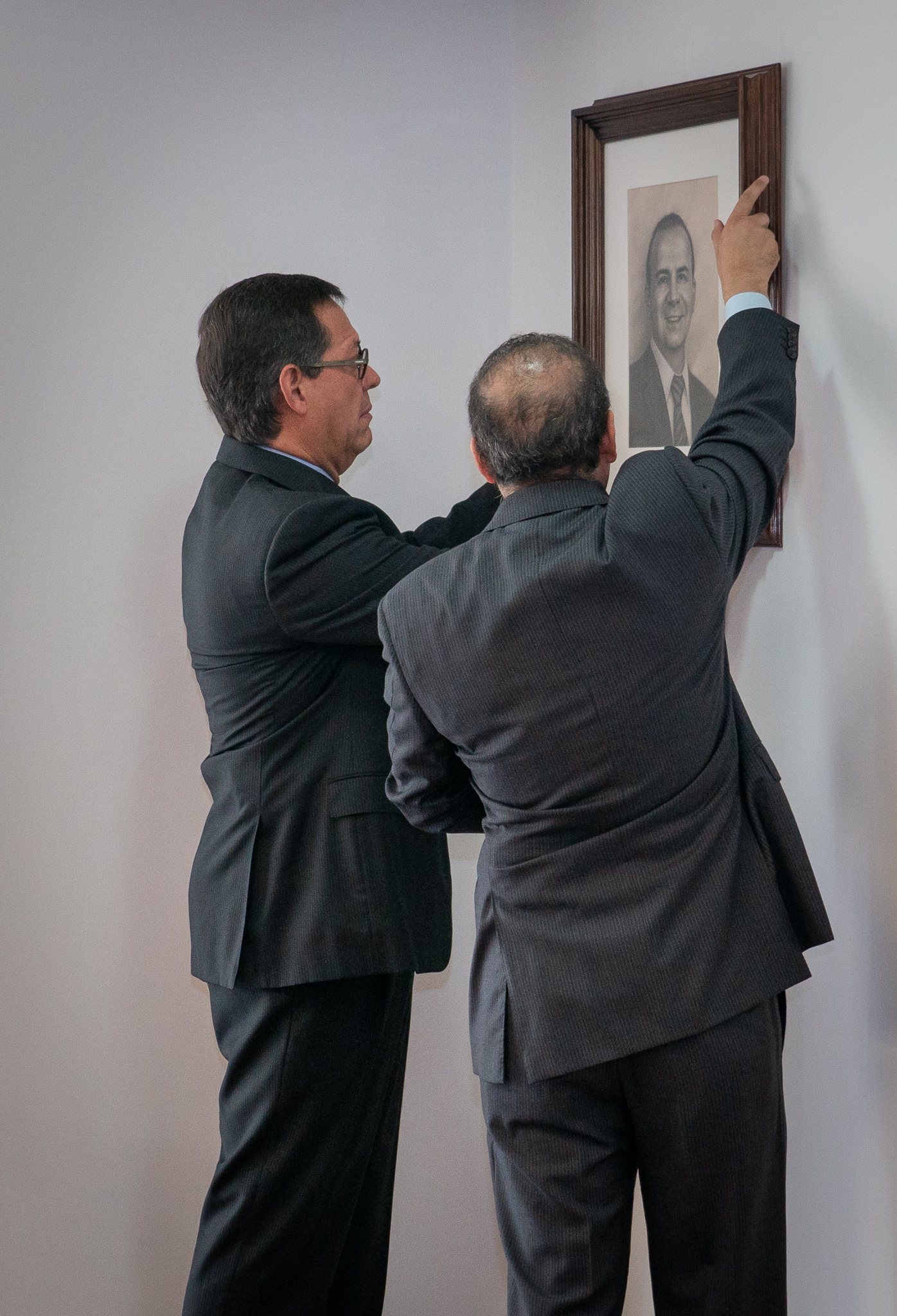 El Secretario de Gobernación, Alfonso Navarrete y El Secretario del Trabajo Roberto Campa colocando  la imagen de la trayectoria del Secretario Navarrete  en la pared del salón de secretarios del Trabajo