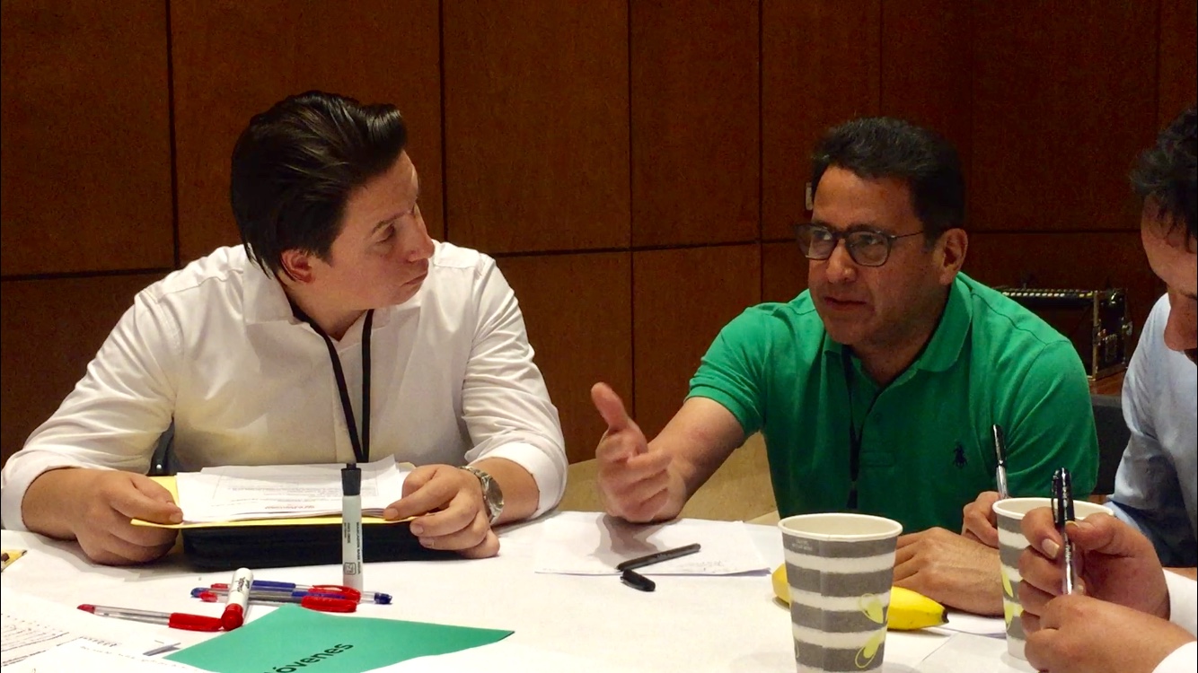 Samuel Torres Méndez, Director de Investigación del Imjuve atento a un joven que expresa sus ideas frente a la mesa de trabajo.