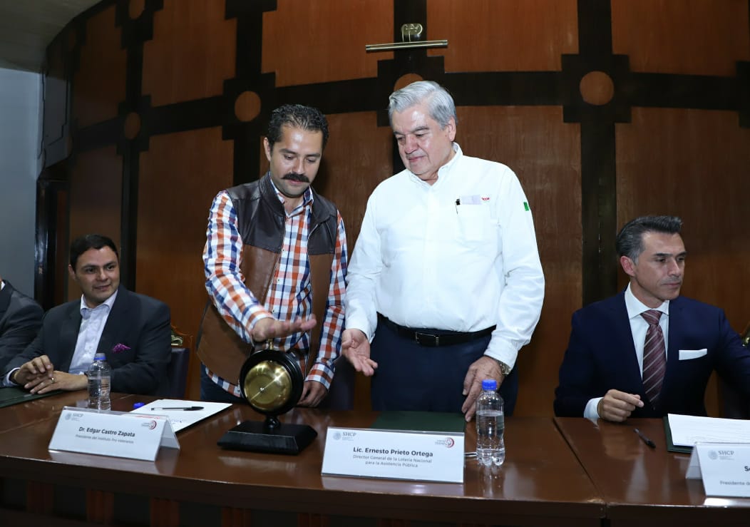 Fotografía donde se observa que Ernesto Prieto Ortega invita a dar el campanazo inicial del sorteo a Edgar Castro Zapata