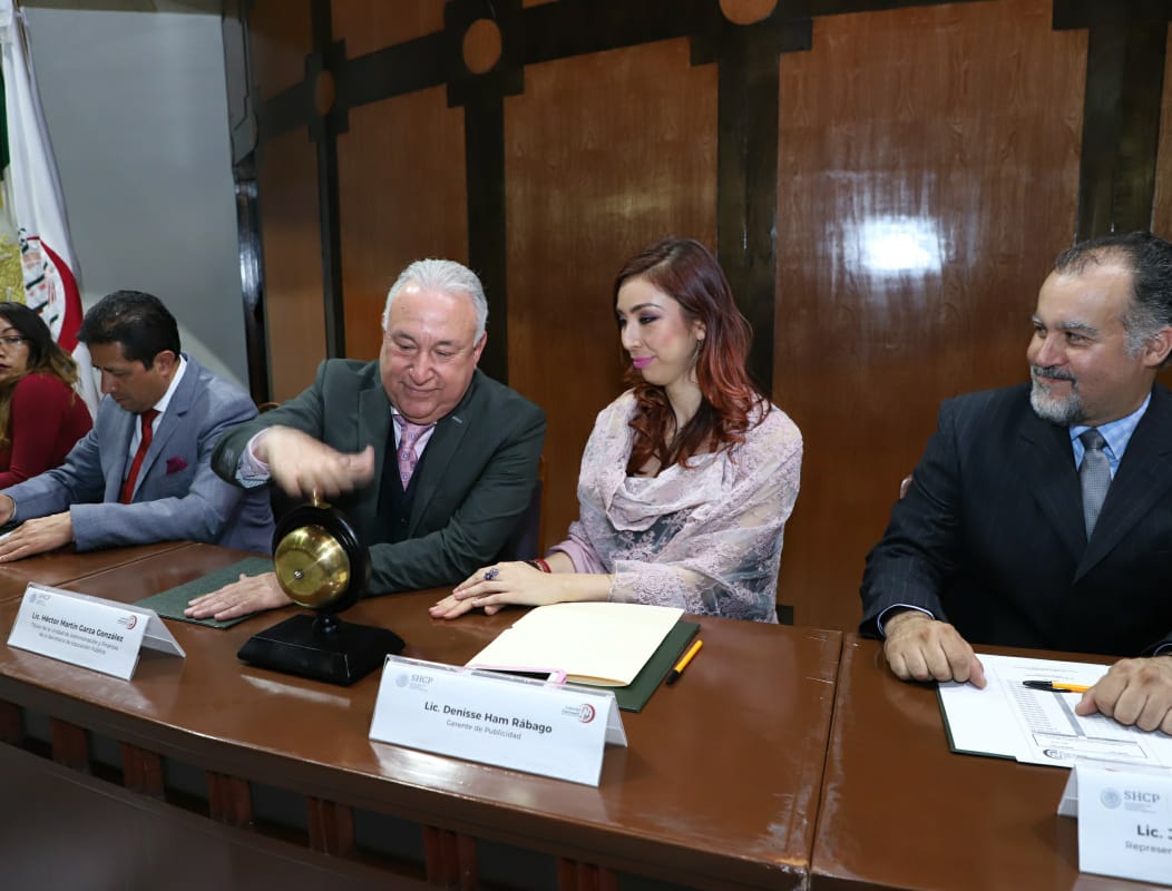 Fotografía donde se observa la invitación de  Denisse Ham Rábago a Héctor Martín Garza González a dar el campanazo inicial del sorteo