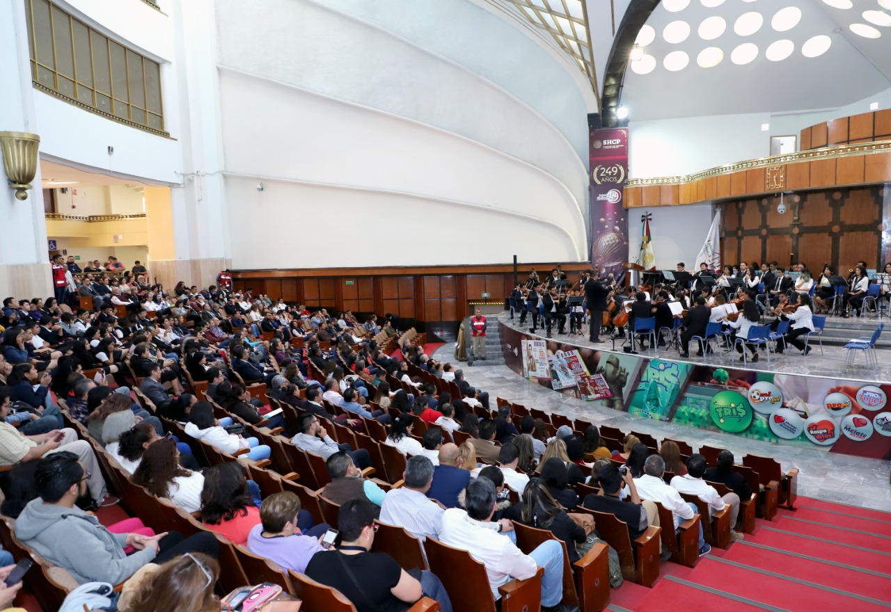 Fotografía del Salón de Sorteos visto desde las butacas donde se observa a los músicos estudiantes de la Orquesta Sinfónica 
