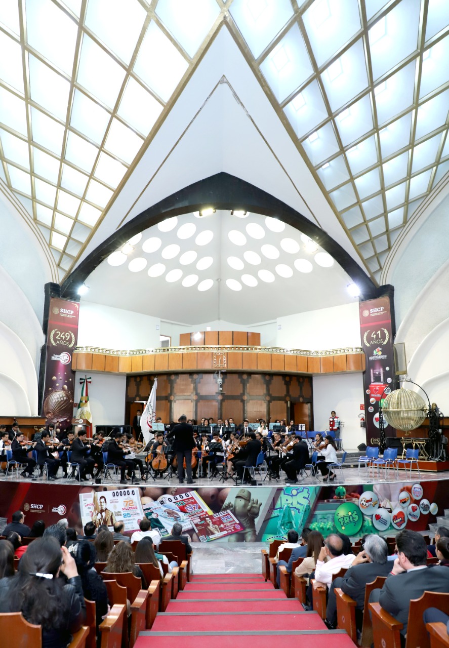 Fotografía donde se observa a los músicos estudiantes de la Orquesta Sinfónica en el Salón de Sorteos