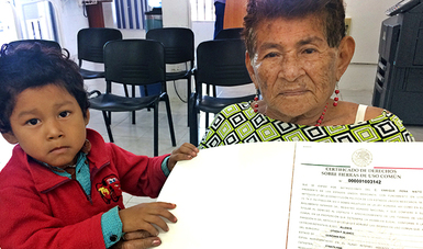 Anciana con su nieto muestran en Quintana Roo su documento agrario.
 