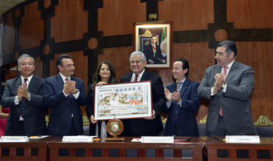 Cinco personas sosteniendo un billete de lotería promocional del sorteo conmemorativo de los 100 años del Artículo 123
