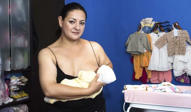 Mujer dando pecho al bebé.