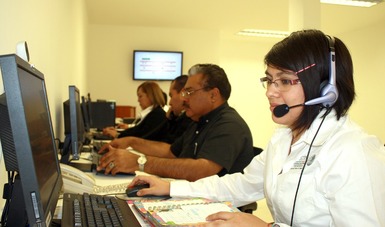 Hombres y mujeres del Centro de Mando realizando un monitoreo vía electrónica a través de computadoras.