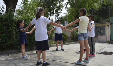 Niños formando un circulo para jugar.