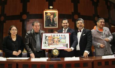 Fotografía en donde se encuentra el Mtro. Guillermo Ceniceros Jorge Cuéllar Montoya y Alejandro Pérez Pineda con la versión ampliada del cachito de lotería 
