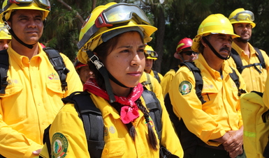 combatientes de incendios forestales recibiendo instrucciones antes de partir a Canadá