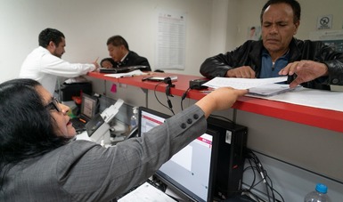 Persona entregando documentación en las nuevas oficinas de Infonacot