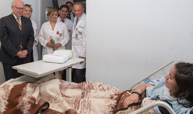 Paciente en habitación de hospital visitada por el Dr. Narro Robles, Secretario de Salud, acompañado por médicos del INPerr