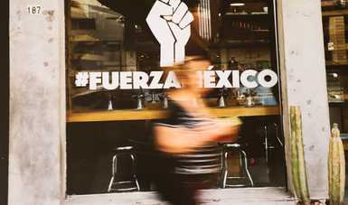 Fotografía representativa de la muestra donde aparece el slogan #FuerzaMéxico con una persona caminando a la mitad del slogan