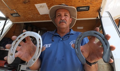 Enrique Gómez, instructor de la Federación Ecuestre Internacional, muestra dos herraduras en el Festival Deportivo Ecuestre en Querétaro. CONADE