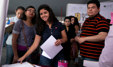 Mujer joven llenando registro en la Primera Feria de Empleo Mujer Emprende