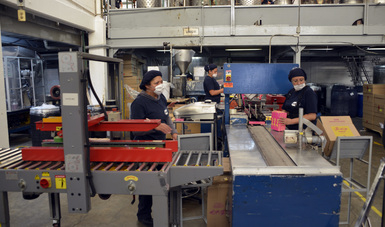 Tres mujeres trabajando en una fábrica.