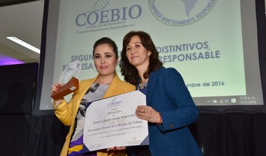 Dos mujeres mostrando un premio en sus manos.