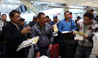 Trabajadores agrícolas revisando sus papeles para partir a Canadá.