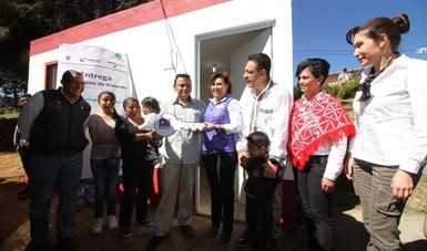 La titular de la SEDATU, Rosario Robles, acompañada del gobernador Omar Fayad, entrega simbólicamente la llave de su cuarto adicional a una familia de la comunidad de  Tepepa, en el municipio de Acaxochitlán.