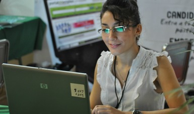 Mujer joven trabajando en una computadora.