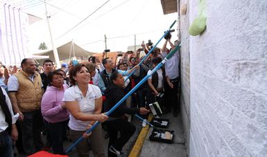 La Titular de la SEDATU, Rosario Robles, rodeada de vecinos, pinta una de las 10 mil fachadas que se pintarán en diversas colonias de Ecatepec.